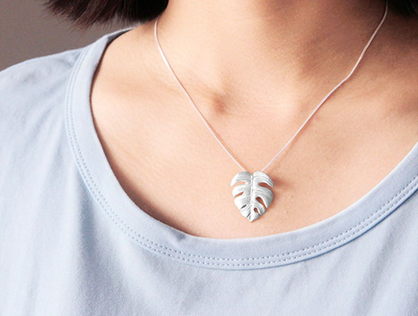 Lady Wears Monstera Necklace Grey Shirt
