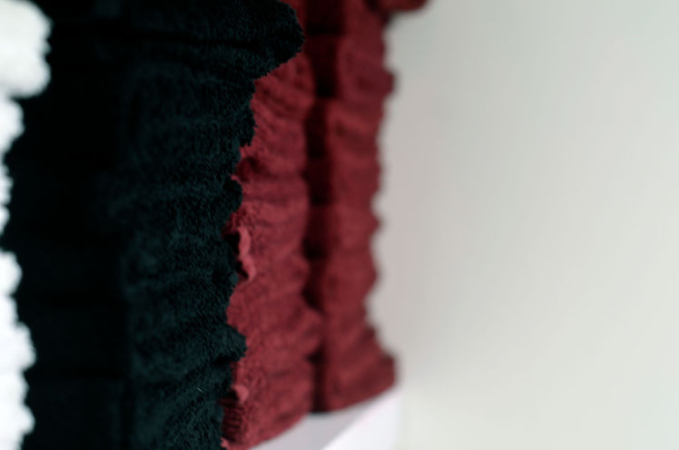 Neatly stacked black and maroon folded towels