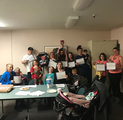 Parents posing with their certificates and families