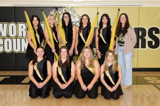 Group portrait of young women with flags, wearing black and gold uniforms.