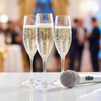 three-champagne-flutes-and-a-silver-microphone-on-a-white-table-at-a-formal-event-photo_ed