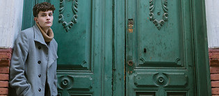 Ung mann utenfor en grønn ytterdør