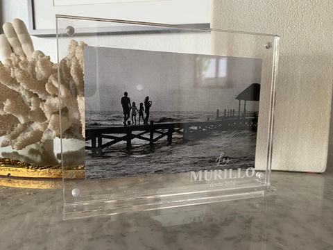 Porta retratos de acrílico grabado con el nombre de la familia con una foto d ela familia a un lado del mar.