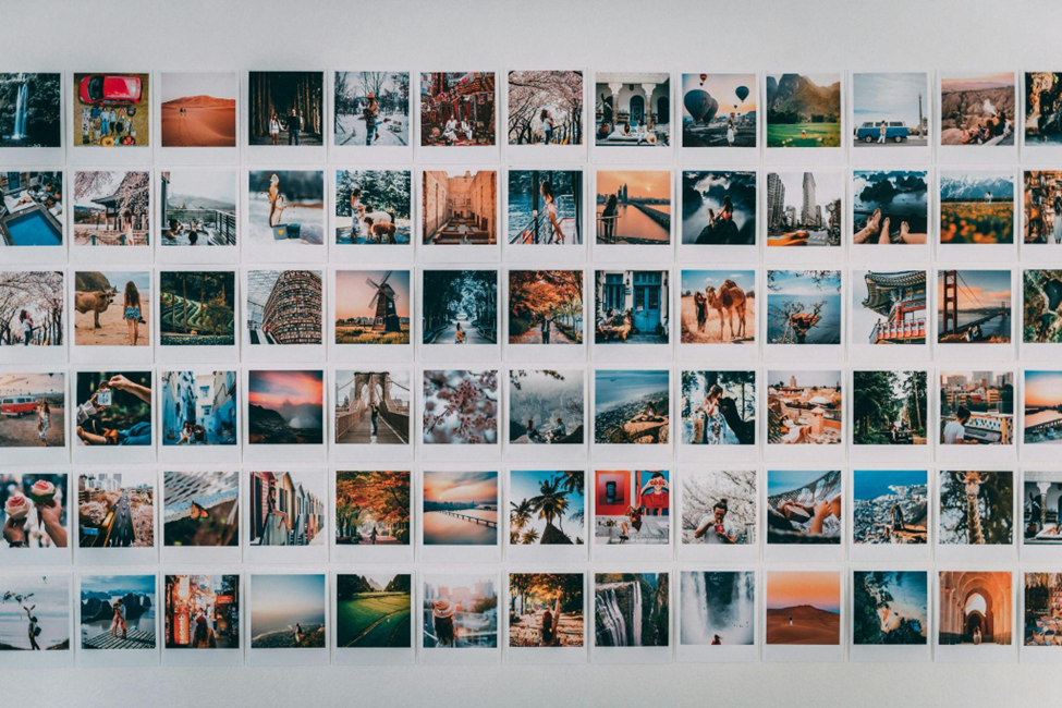 A wall display of various travel photos showing landscapes, architecture, and people in different settings, evoking wanderlust and adventure.