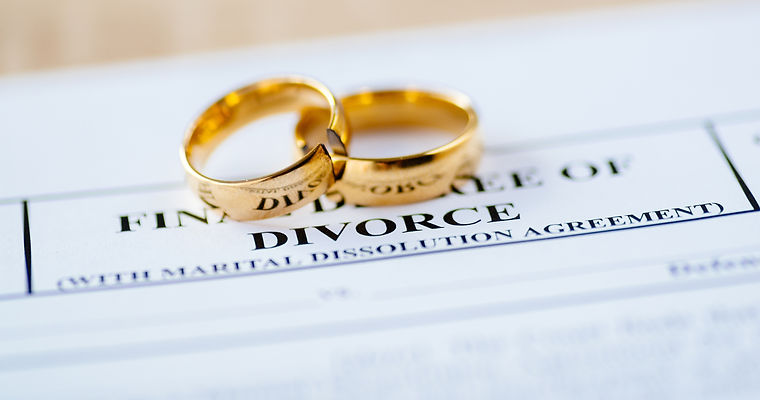 Two broken golden wedding rings divorce decree document. Divorce and separation concept.jp