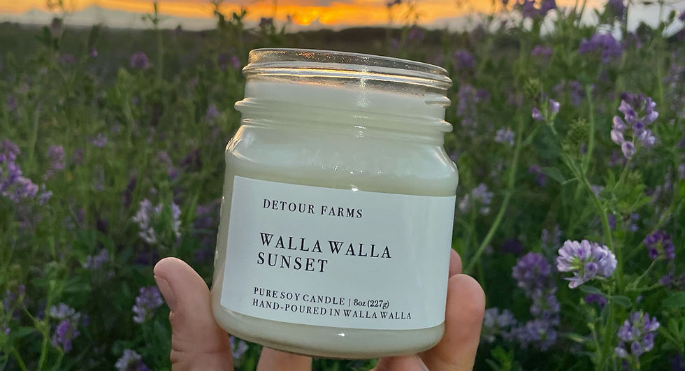 Walla Walla Sunset pure soy candle from Detour Farms held up in a flowering field at sunset, 8oz hand-poured soy wax candle