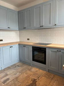 Bespoke kitchen with light blue shaker cabinets and timber worktops.