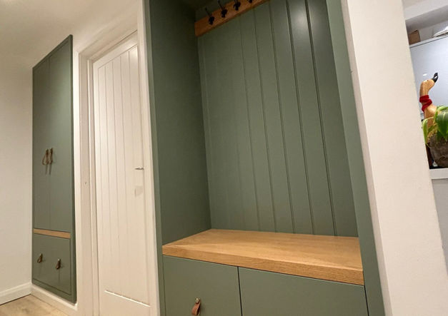 Custom hallway storage with bench seating, coat hooks and concealed compartments.