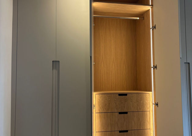 Fitted wardrobe with open section, internal drawers, and tall hanging space.