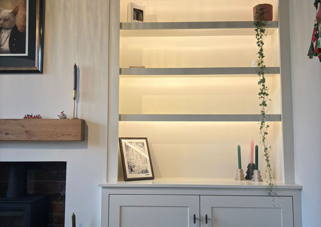 Custom built-in unit with cupboards, shelving, and space for a television.