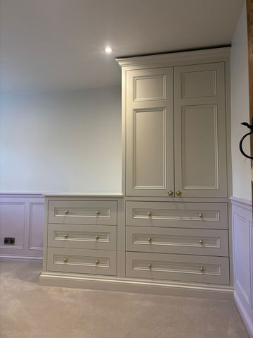 Built-in cabinetry with painted shaker doors and drawers, fitted neatly into a living space.