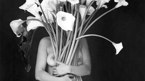 Une femme nue, embrassant un grand bouquet de fleurs qui lui cachent le visage