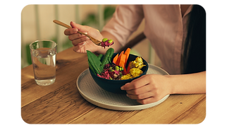 woman-sitting-at-the-wooden-table-and-holding-a-fo.png