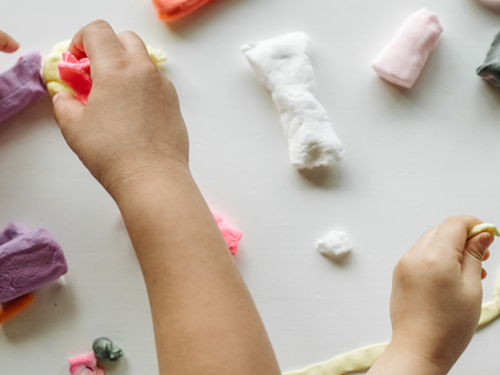Toddlers playing with colorful Play-Doh during an everyday play activity