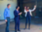 Three individuals celebrating about cutting a ribbon at an opening ceremony to a plant.