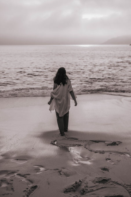 Mulher caminha em direção ao mar