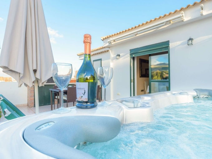 spaans-dakterras-met-jacuzzi-fles-cava-en-waterbubbels