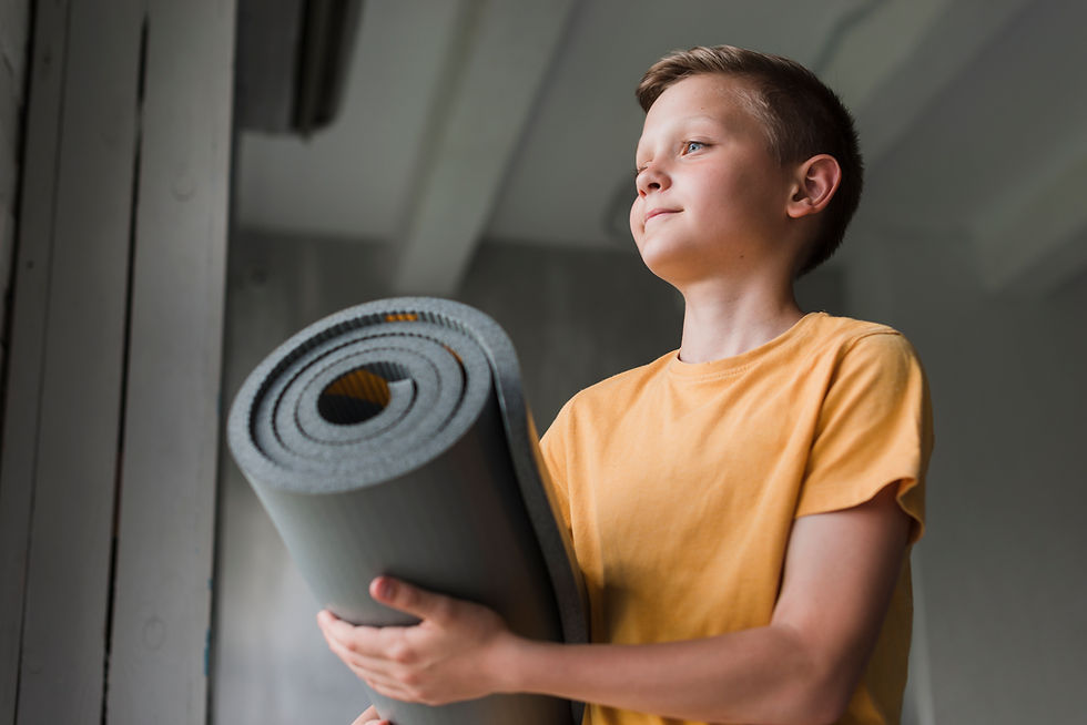 low-angle-view-boy-holding-rolling-grey-exercise-mat.jpg