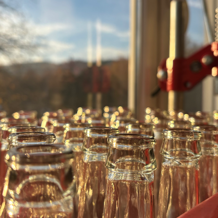Viele leere Flaschenhälse in einer roten Kiste