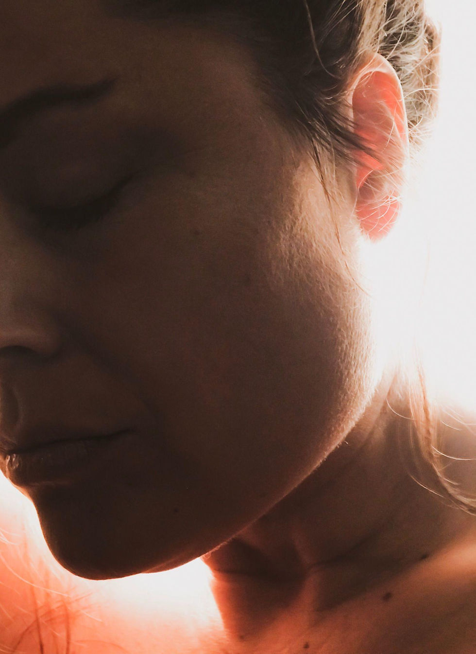 Person resting with eyes closed in soft light, representing relief from pain and deep relaxation.