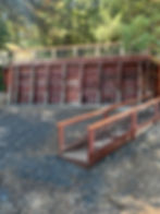 Wooden retaining wall with concrete base and ramp