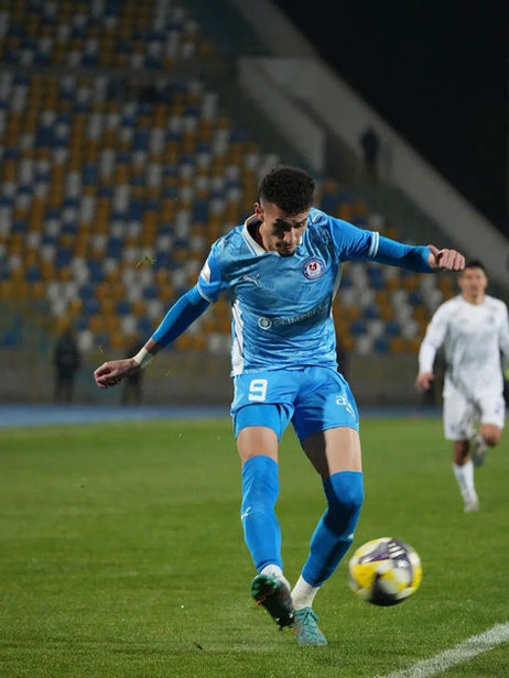 Jogador de futebol profissional em campo durante partida.