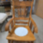 Antique wooden rocking chair with a white padded seat