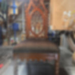 Ornate gothic style carved wooden chair with upholstered seat