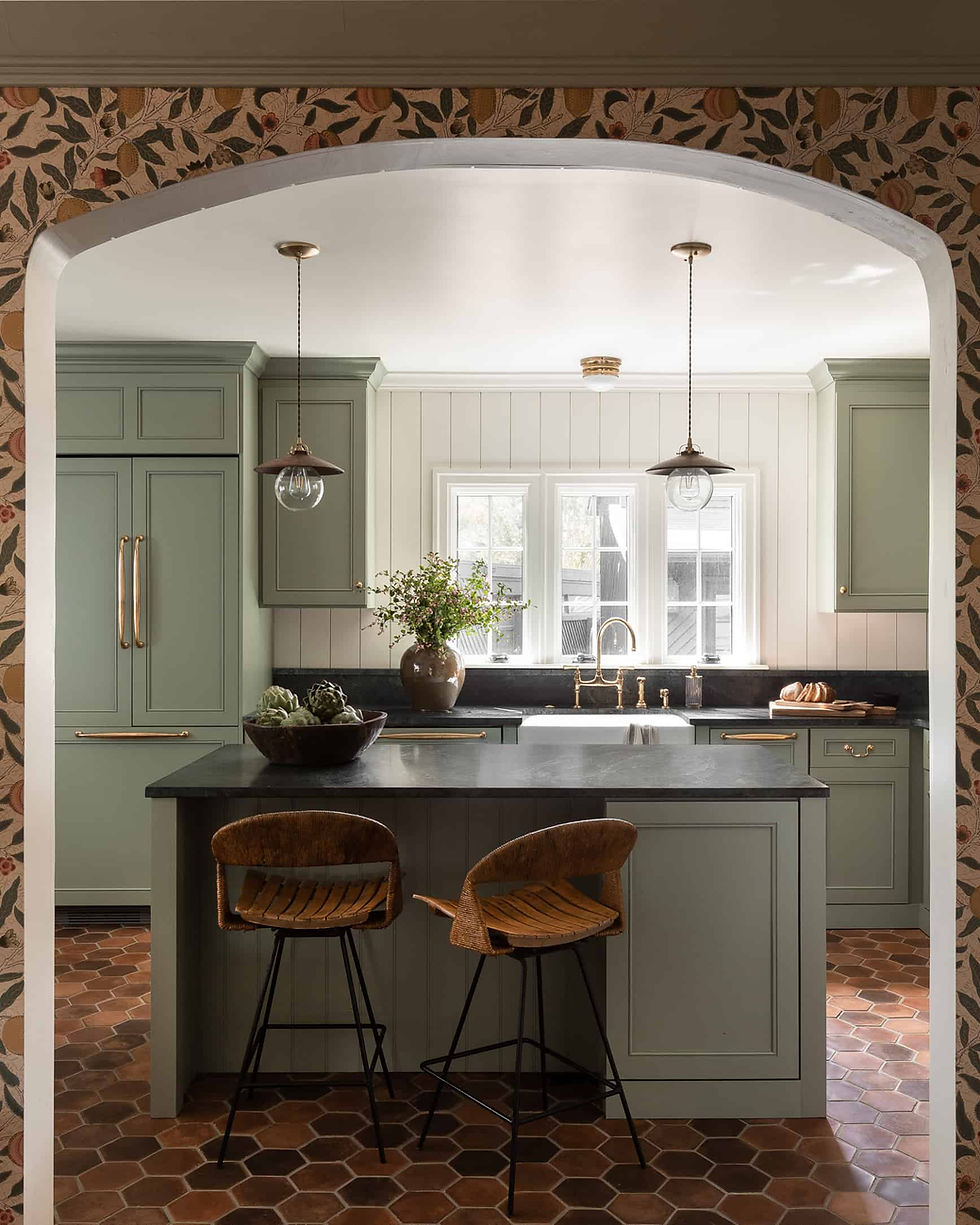 Credit: Heidi Caillier Design. This kitchen leans into a sophisticated, earthy palette. The deep, grounding terracotta of the beaded Shaker cabinetry provides a striking, soulful warmth, perfectly balanced by the cool, honed surface of the soapstone countertops. A crisp, vertically applied shiplap backsplash keeps the aesthetic clean and bright, while the iconic Arthur Umanoff stools add a layer of vintage mid-century charm. Finished with oversized, hand-finished pendants, the space feels thoughtfully curated, bridging the gap between rustic charm and modern luxury.

