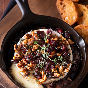 Baked Brie in Skillet with Cranberry, Walnuts, Maple Syrup, and Thyme Recipe,A whole Brie wheel baked until molten in a cast iron skillet, topped with tart cranberries, toasted walnuts, Canadian maple syrup and fresh thyme.The appetizer that takes 20 minutes and earns every compliment it gets.
