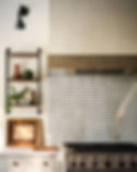 A kitchen with patterned backsplash tiles, a stove, and a wooden shelf holding vases and a plant. Warm lighting and a wall-mounted lamp. on HomeFindss by STEVE & FILIP DESIGN
