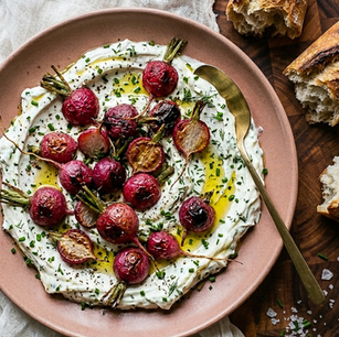 Roasted radishes lose their sharpness in the oven and become something sweeter and more tender — served over garlicky yogurt and finished with fresh chives. A light, unexpected spring side dish.