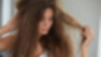 A woman with frayed hair and hair breakage