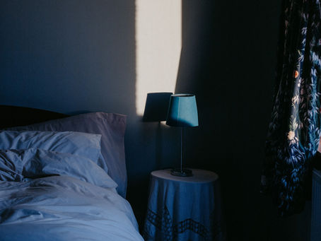 Low lit room with empty bed