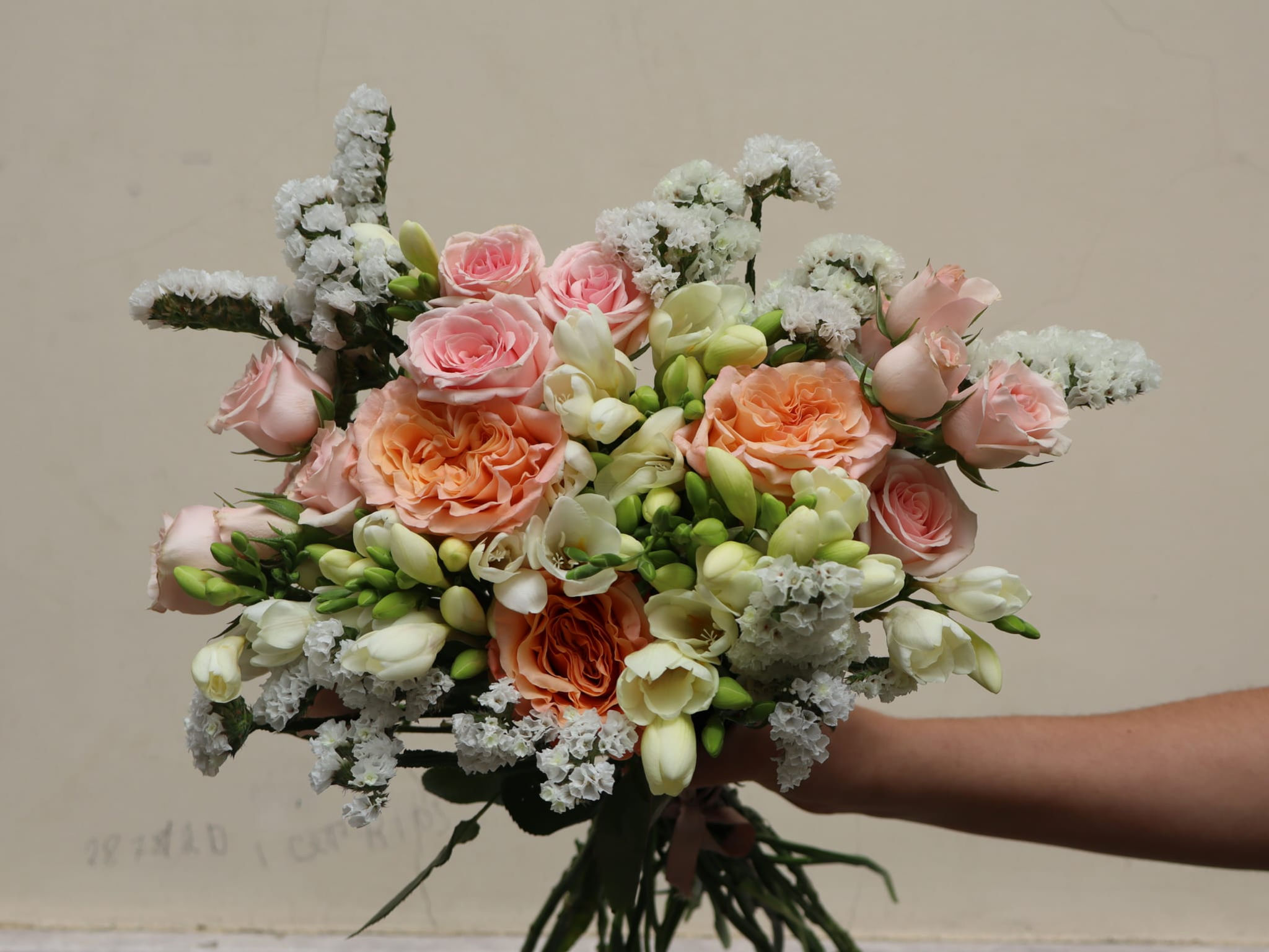 Bouquet de rosas laranja pastel e frésias brancas — Pequeno Jardim Lisboa.