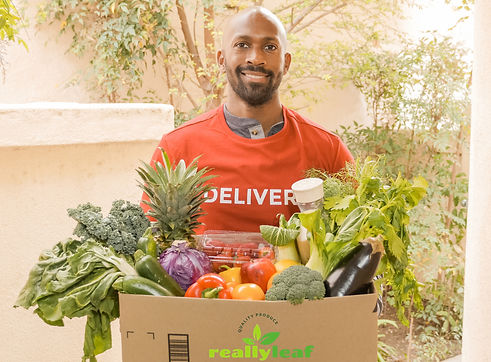 A man carrying box of fresh Really Leaf fruits and vegetables