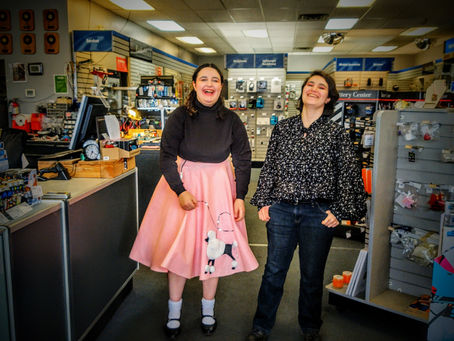 Becky Northaven's daughters smile in the Sequim Electronics store aisle, symbolizing five decades of community and technological evolution.