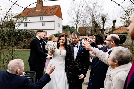 Candid confetti photo with Houchins house behind newlyweds