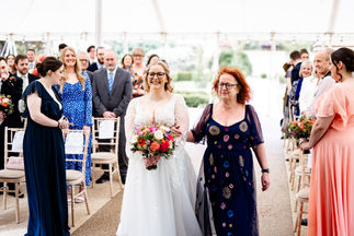 Bride and mum walking down garden aisle at Houchins wedding