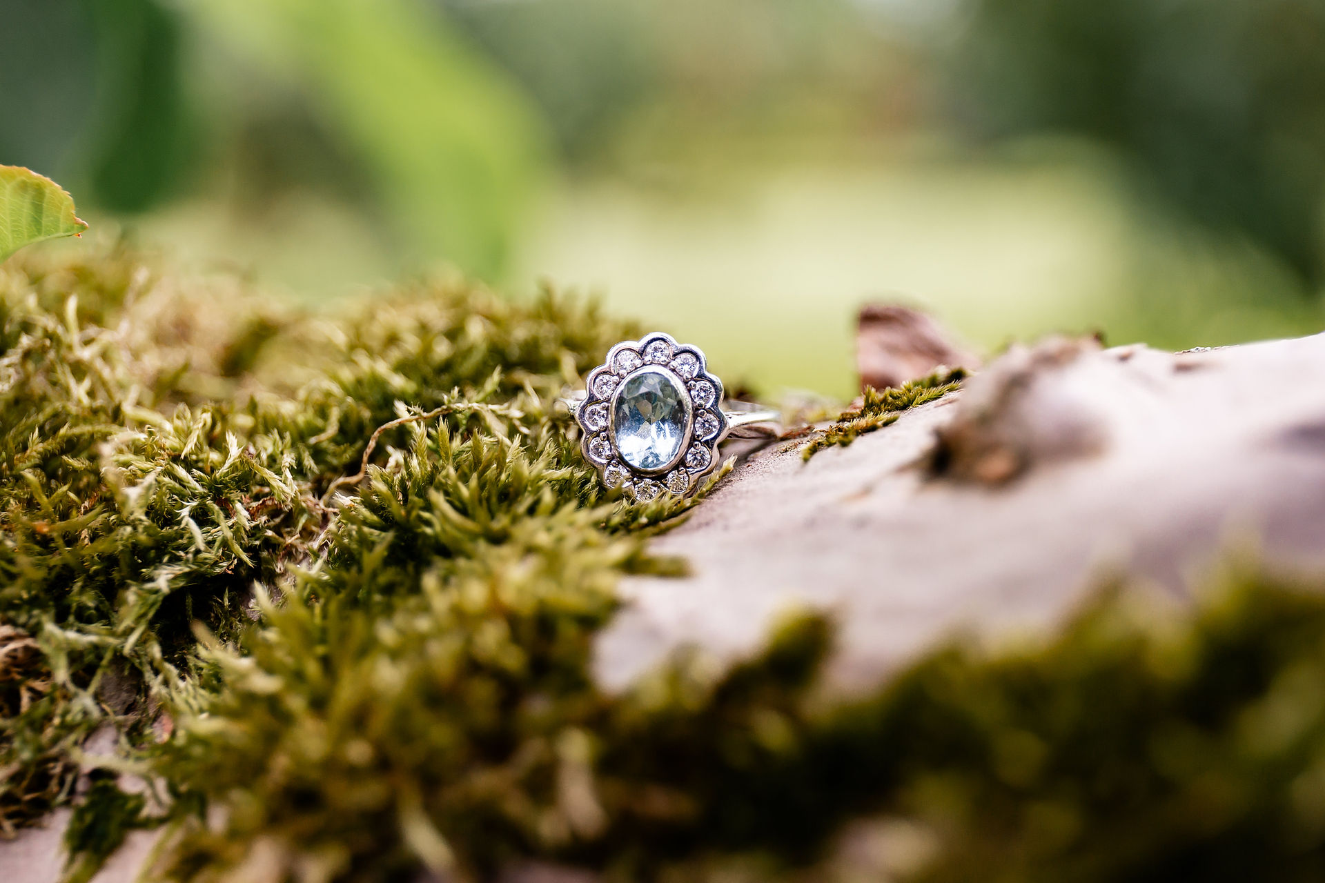 Vintage engagement ring resting on moss in the meadow at Wellington Wood wedding venue in Norfolk 