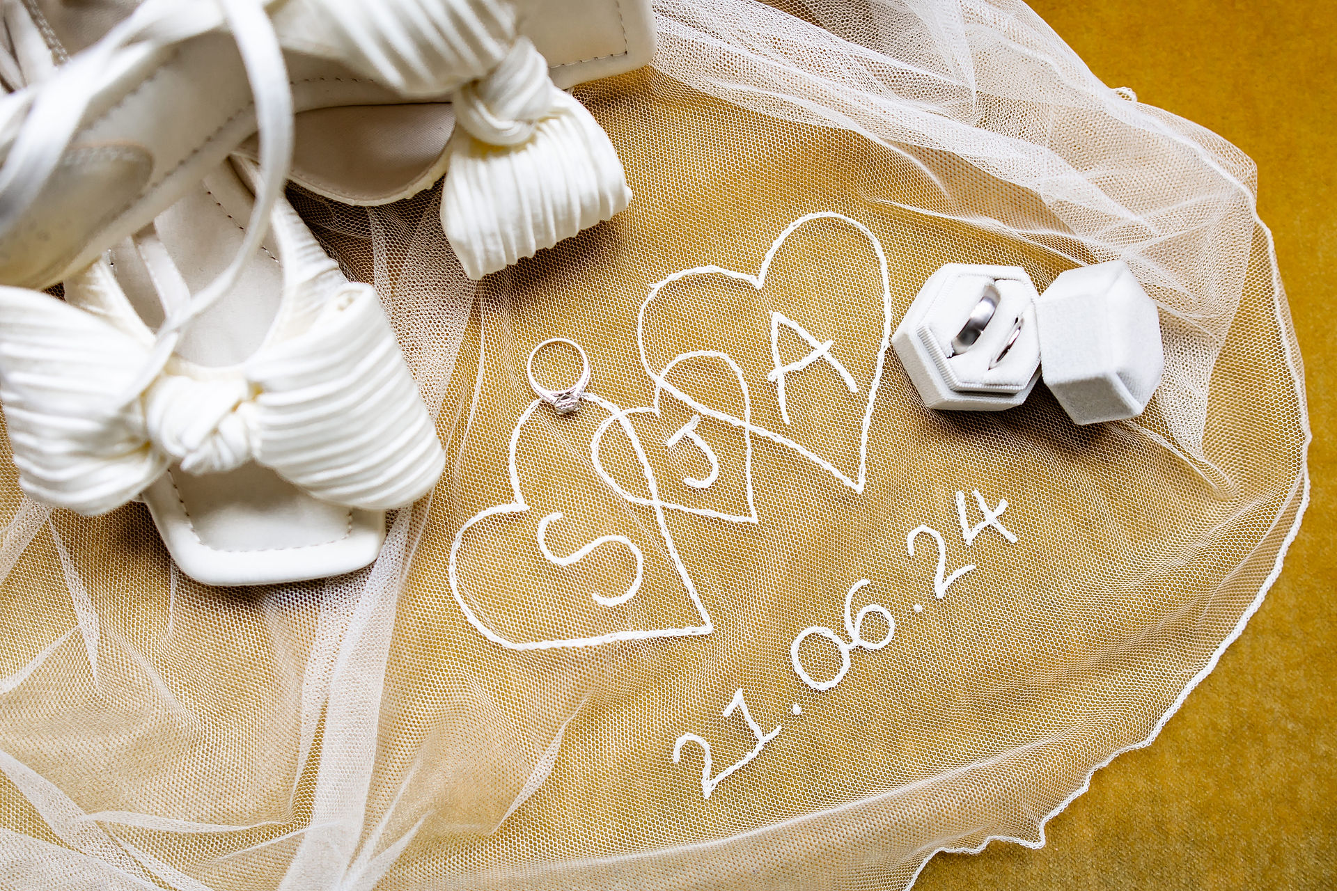 Flay lay of bridal details on a mustard velvet sofa at Houchins wedding venue