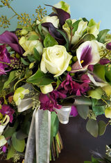 Bridal bouquet with roses, orchids, mini calla lilies, and other mixed flowers in shades of green, white, and purple. November fall wedding