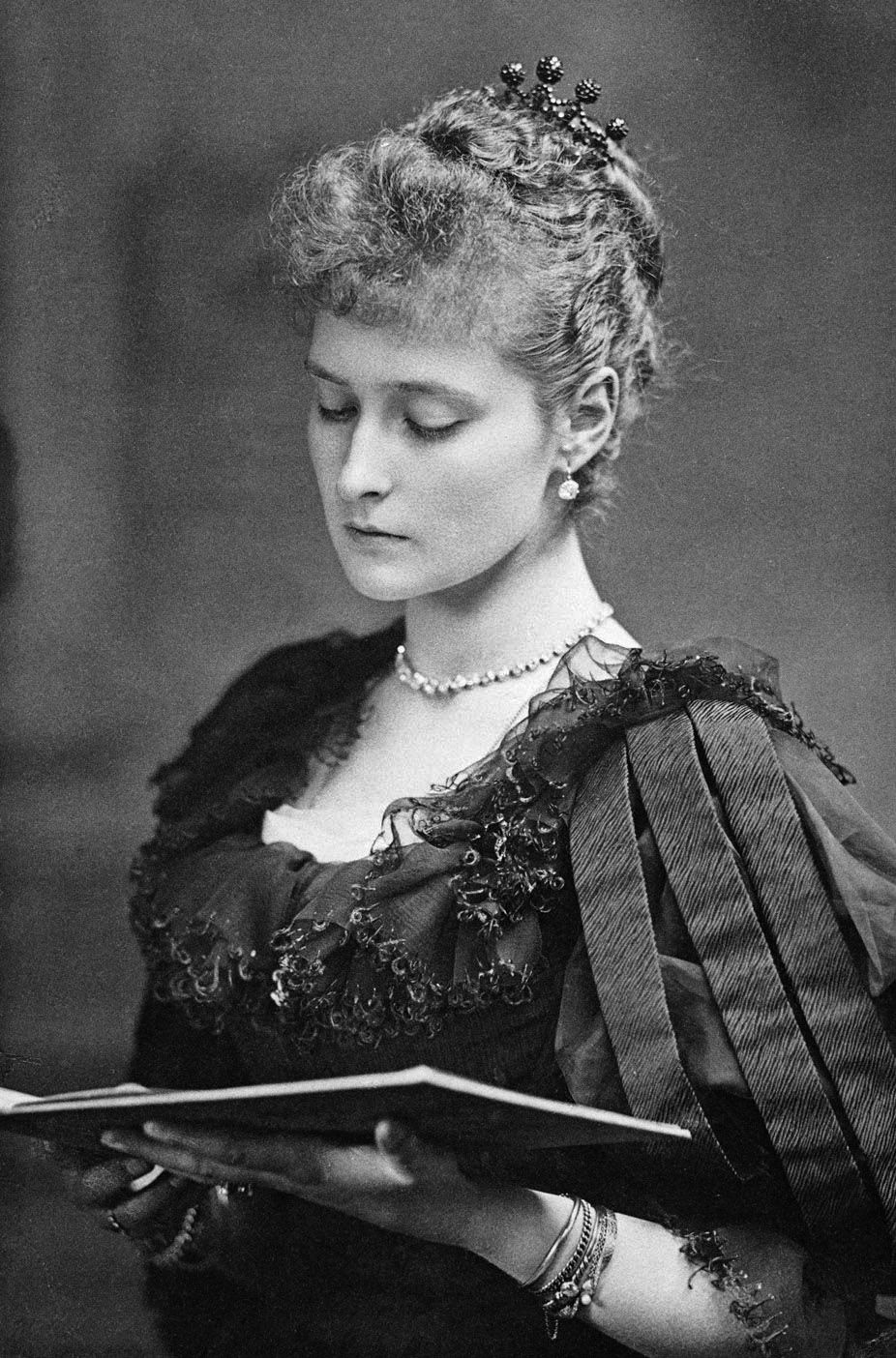 Photograph of Princess Alix of Hesse-Darmstadt in 1890; a lovely young woman in late Victorian dress, reading a book