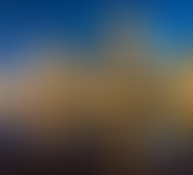 Foto com prédios modernos iluminados durante a noite em Doha. Estão refletidos em um espelho d'água.