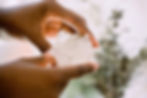 close up of hands holding onto a chunk of white crystal