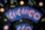 Purple oracle cards spread out on a black table cloth with lit candles, crystals, and a pendulum