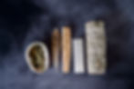 sticks, feathers, shells, and gems in a line on a dark background