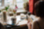 Woman sitting at desk with lit candles and coffee mugs