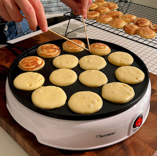 Mini pancake che vengono girati con due stecchini di legno