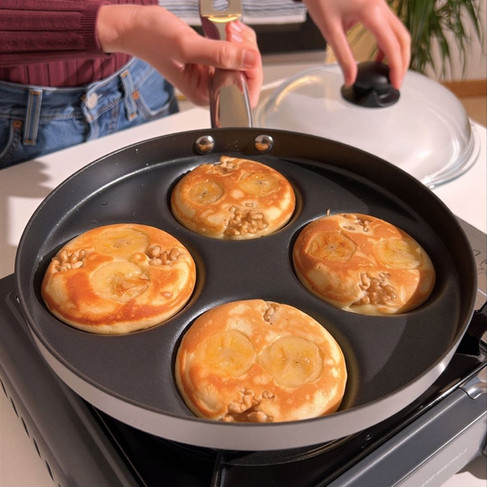 Quattro pancake mentre cuociono sulla padella con i buchi